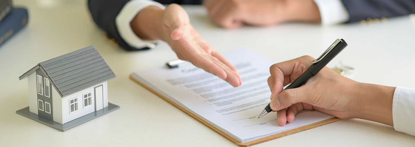 Hand with a pen next to a contract